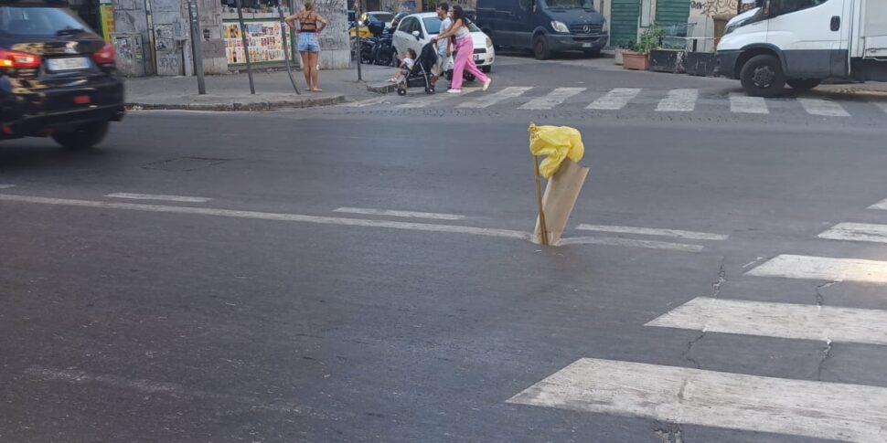 A Palermo buca in strada al centro di via Roma, segnalata con un bastone e un sacchetto